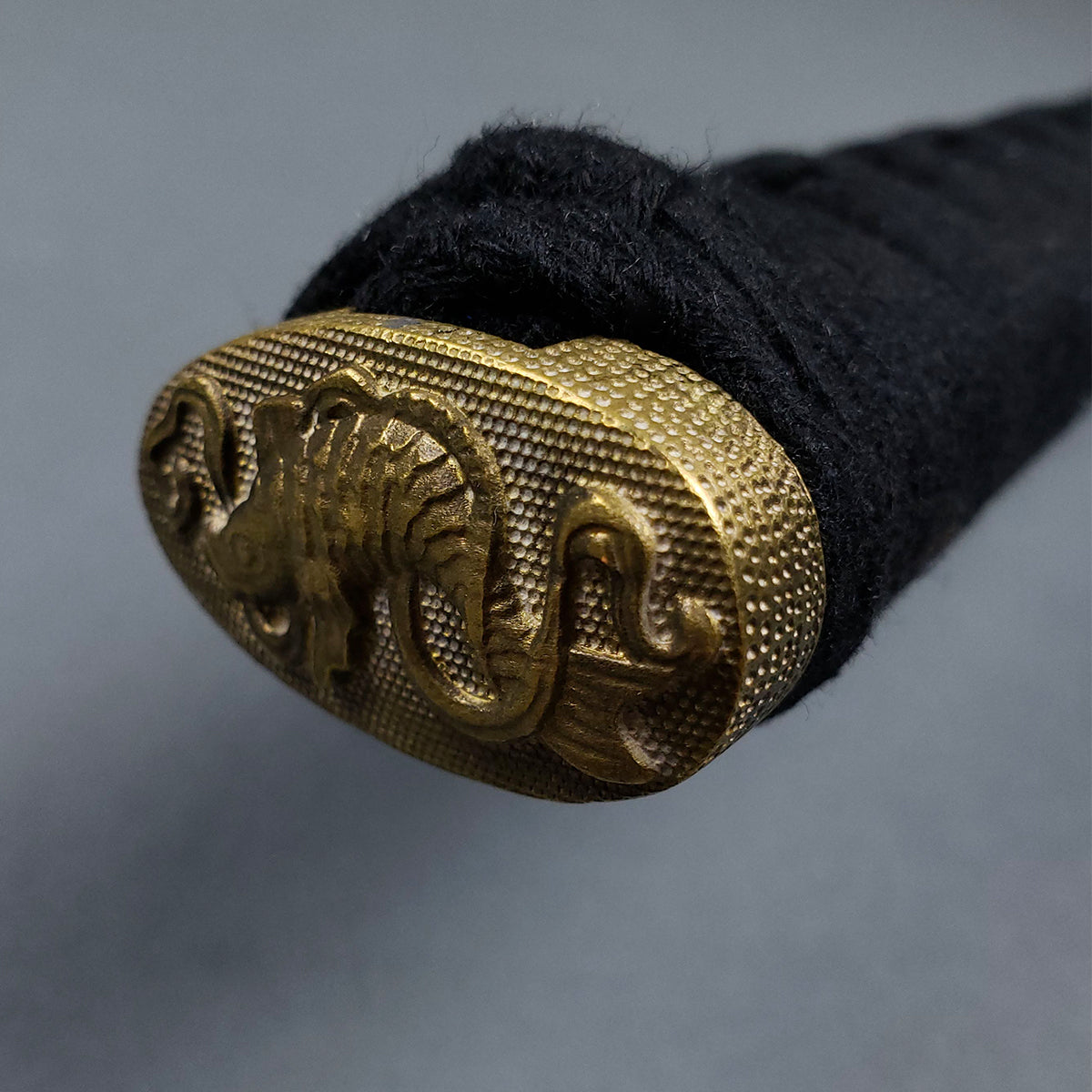 Close-up of Musashi Tsuru Katana samurai sword handle with detailed golden dragon pommel and black wrap