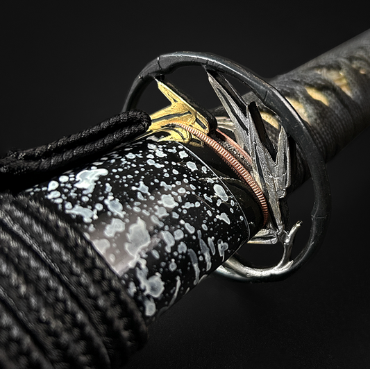 A close-up of a habaki on a katana.