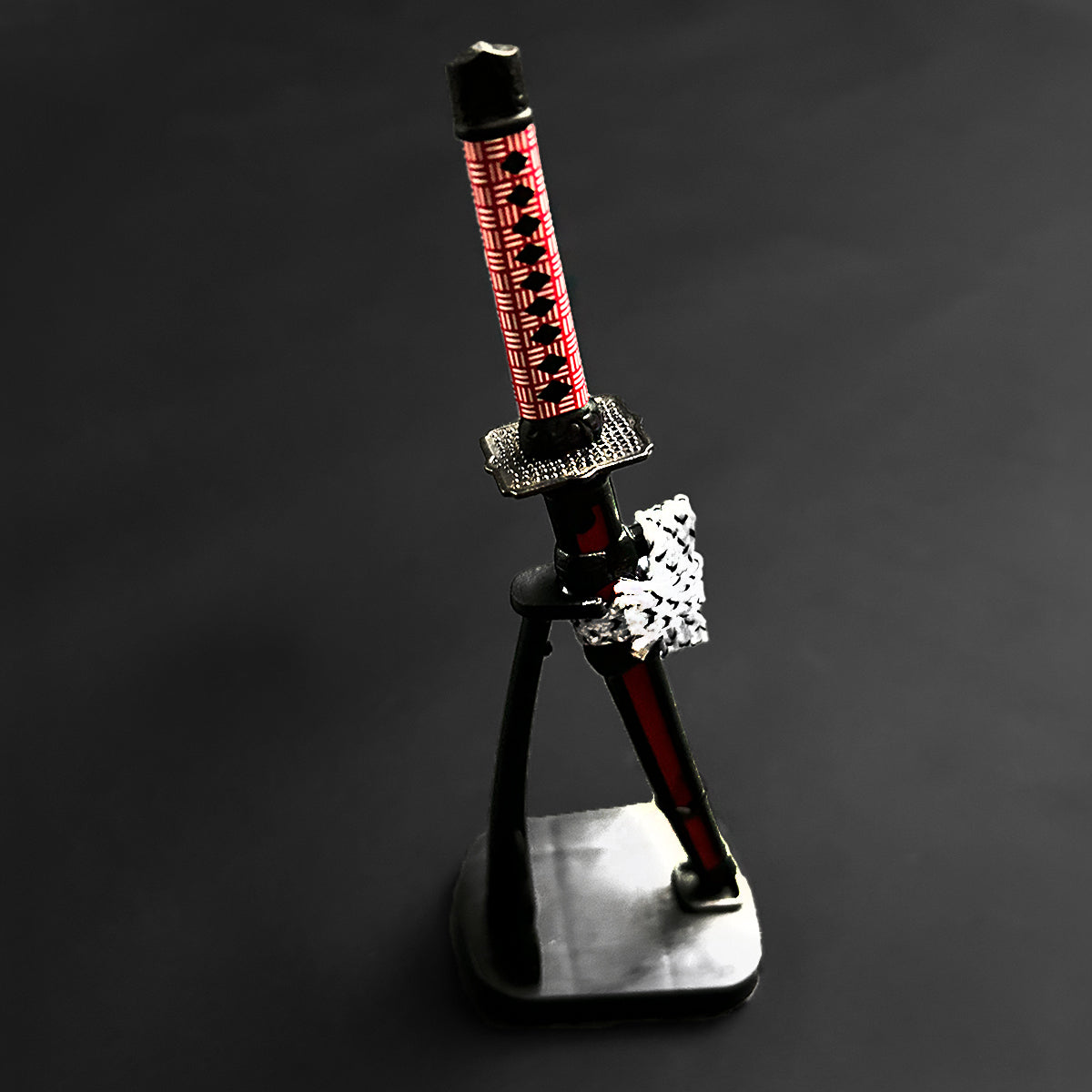 Musashi Swords Mini Katana Mini Samurai Sword Letter Opener with red and black handle on display stand