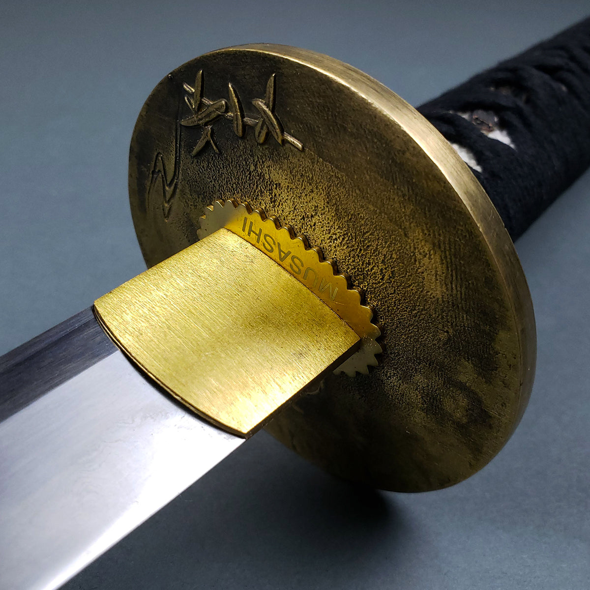 Close-up of Musashi Tsuru Katana samurai sword blade and detailed gold tsuba by Musashi Swords
