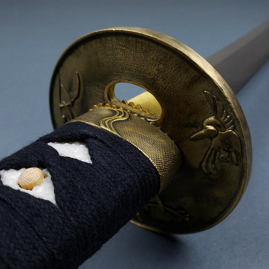 Close-up of the detailed tsuba and black wrapped handle of the Musashi Tsuru Katana samurai sword